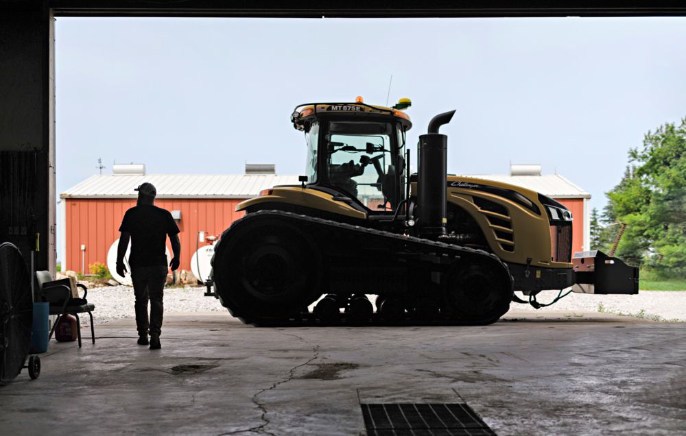 Erik standing with farm machinery