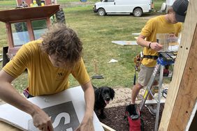 From left, Leonard, Bella and Noah work on installing a bay window.