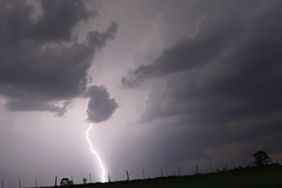 Lighting strikes over a field.